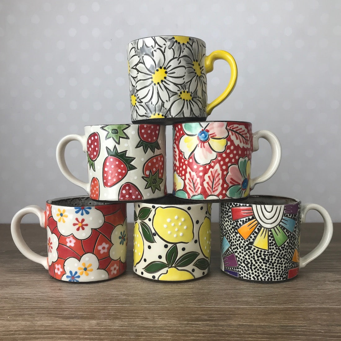 pyramid stack of 6 handpainted mugs in assorted colorful patterns with flowers and fruit